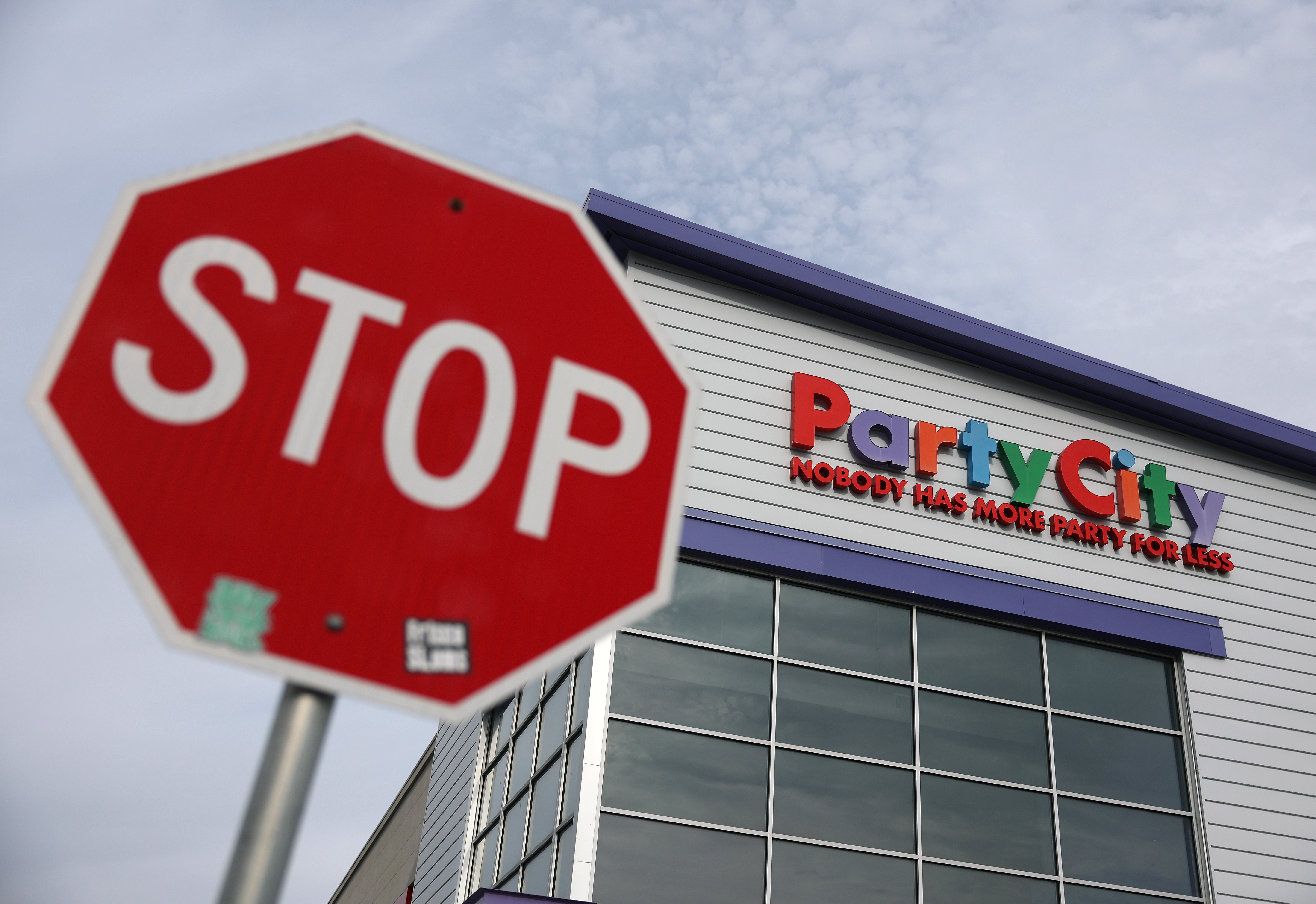 A Party City store, with a stop sign out front.