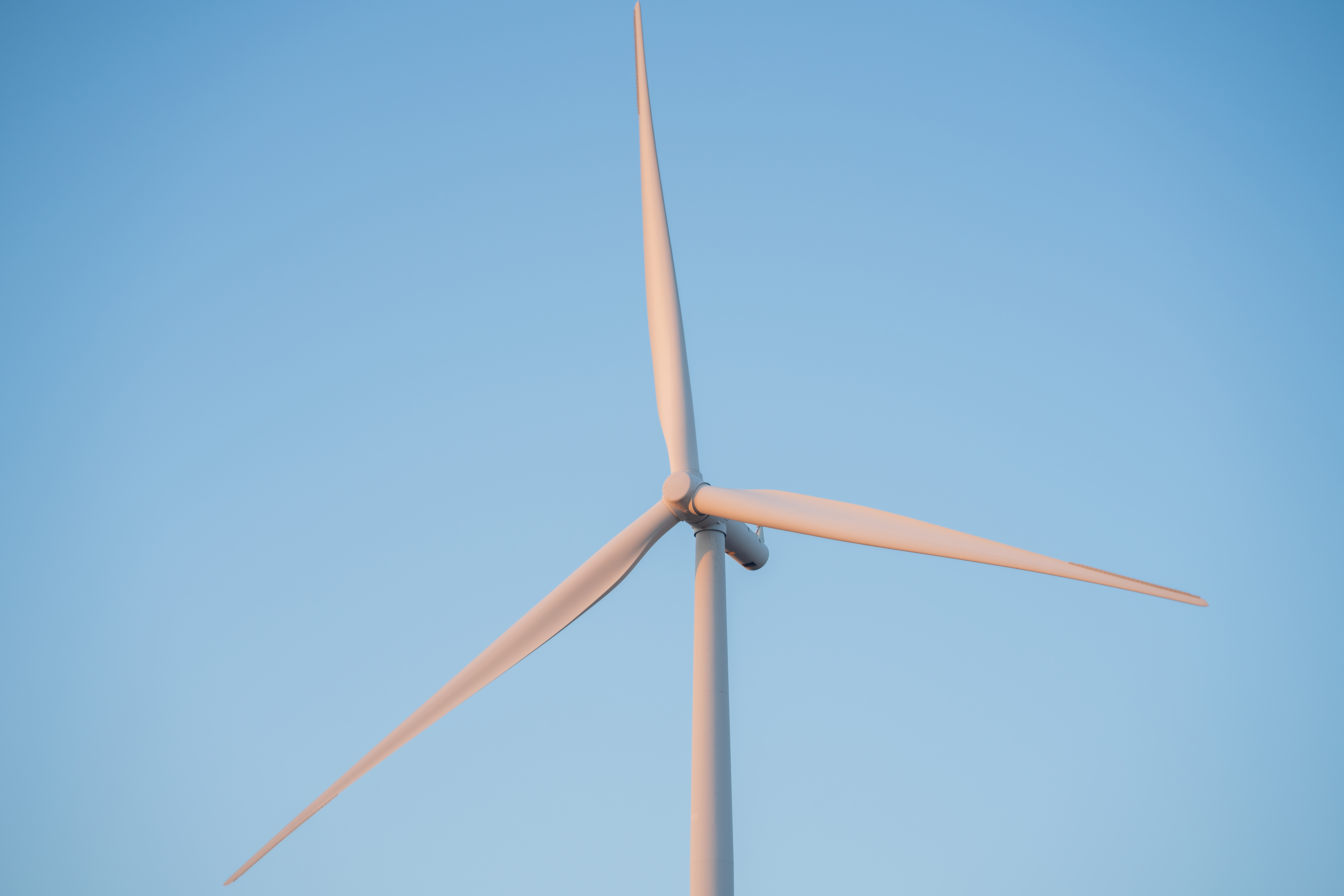A wind turbine against a blue sky.