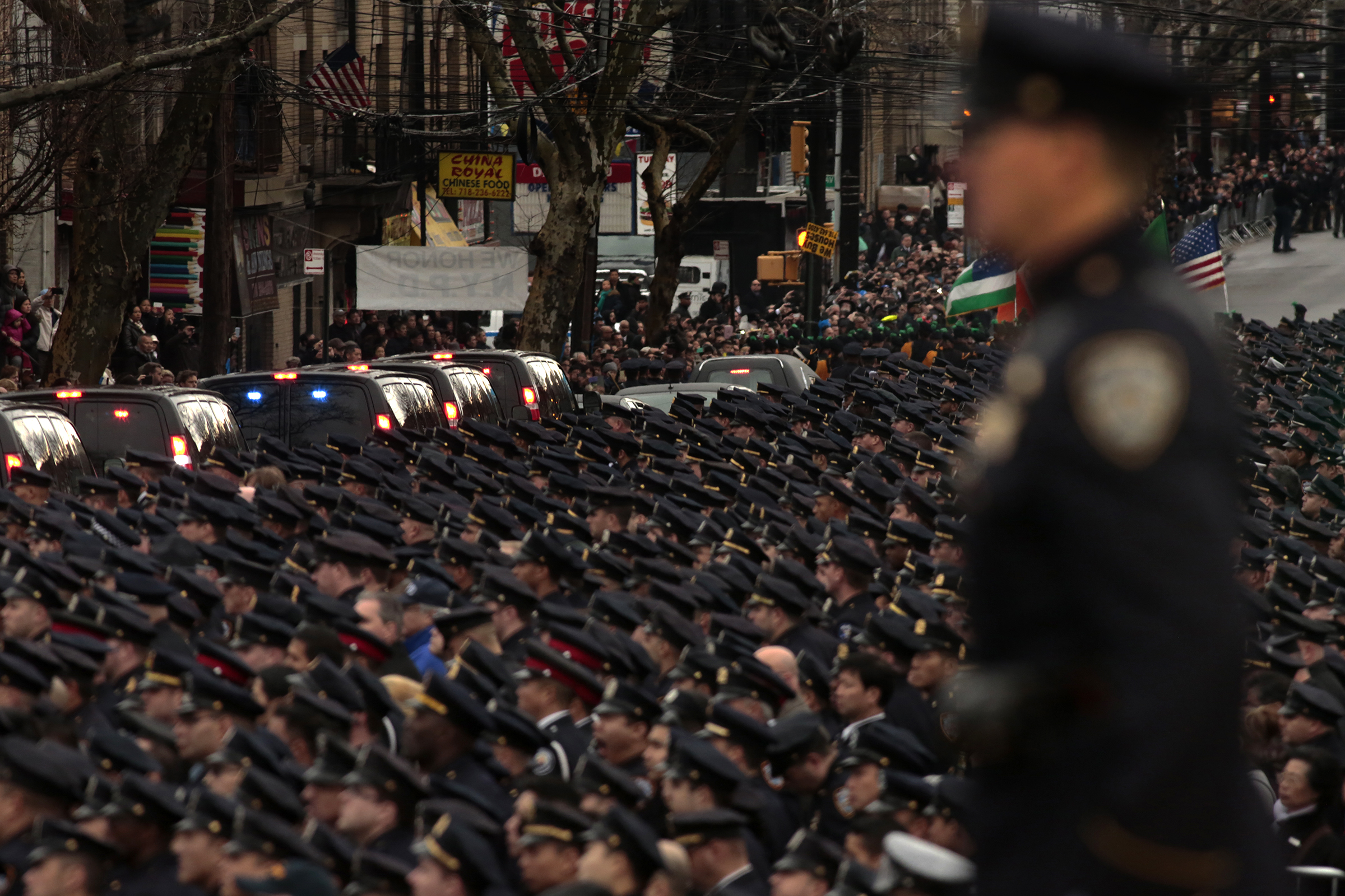 BROOKLYN, NEW YORK--JAN. 4, 2015--A sea of blue uniformed officers line the street in honor of polic BROOKLYN, NEW YORK--JAN. 4, 2015--A sea of blue uniformed officers line the street in honor of police officer Wenjian Liu, as his body leaves the funeral for burial in Brooklyn, New York. Police officer Wenjian Liu, age 32, was shot in the head with partner Rafael Ramos, 40, on December 20, 2014 as the pair sat in their patrol car.