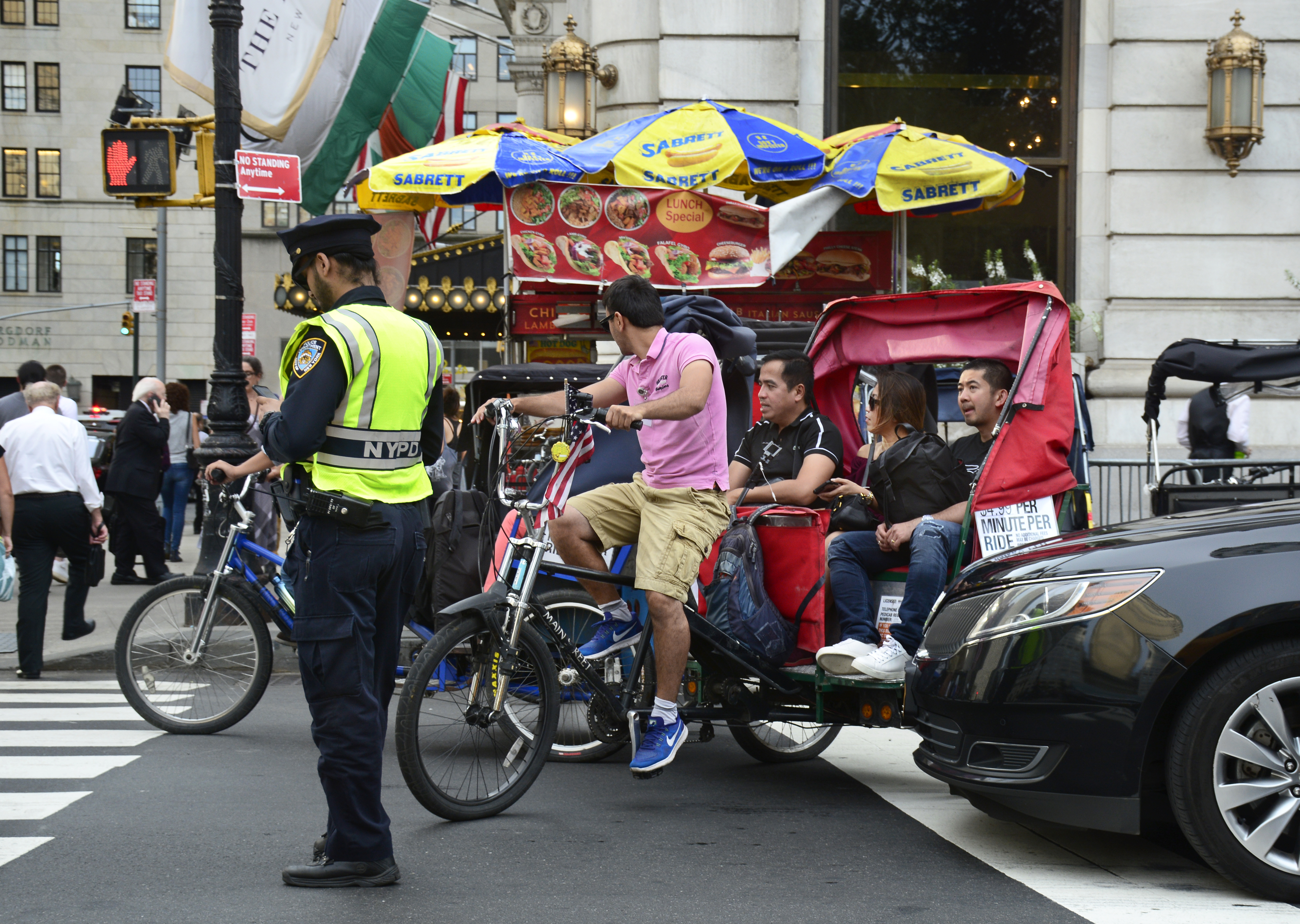 A pedicab with passengers on an NYC street.