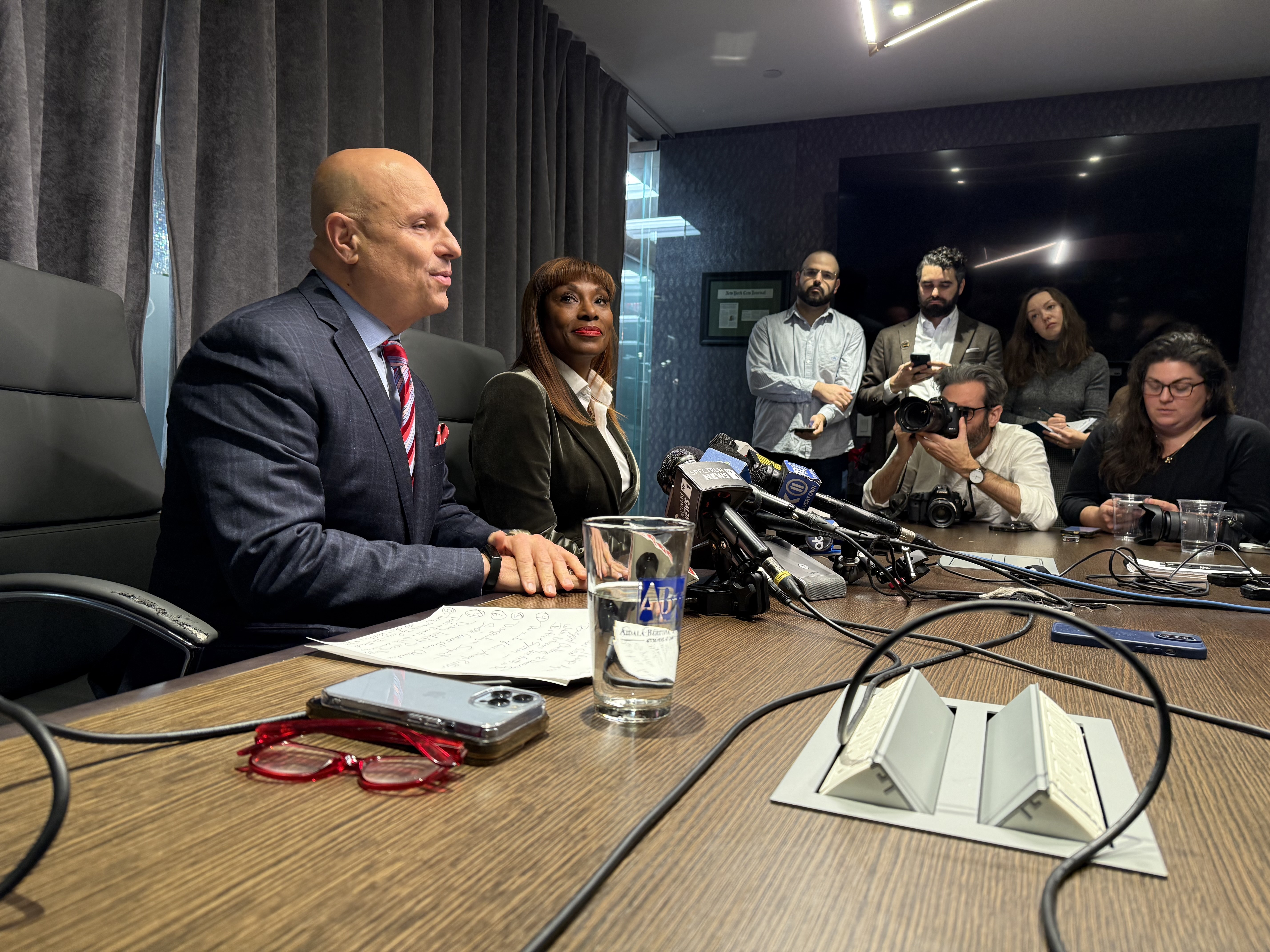 Eric Adams' former chief adviser Ingrid Lewis-Martin sits with her lawyer and several journalists at a table.