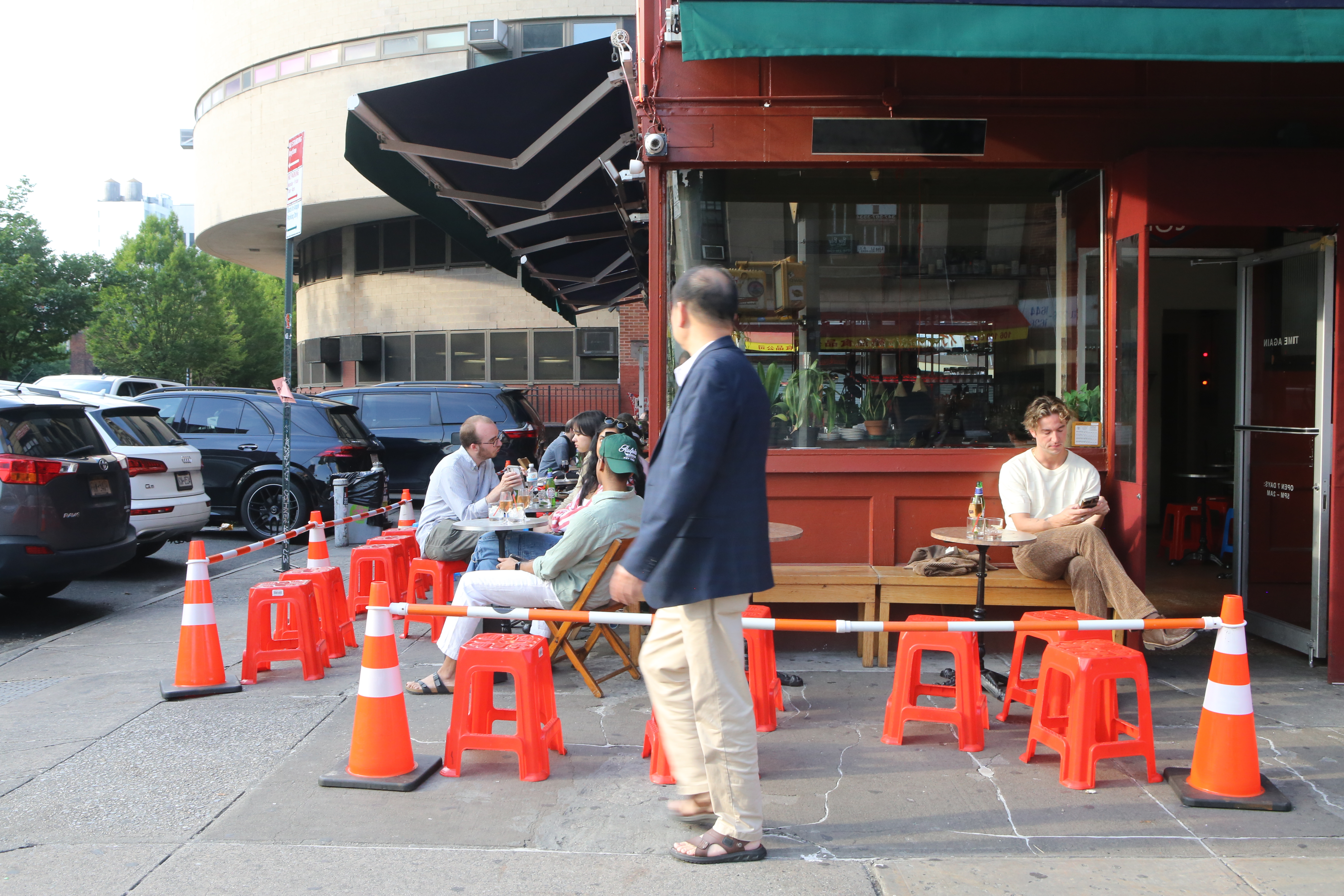 A bar on a Manhattan city corner with cones in front.