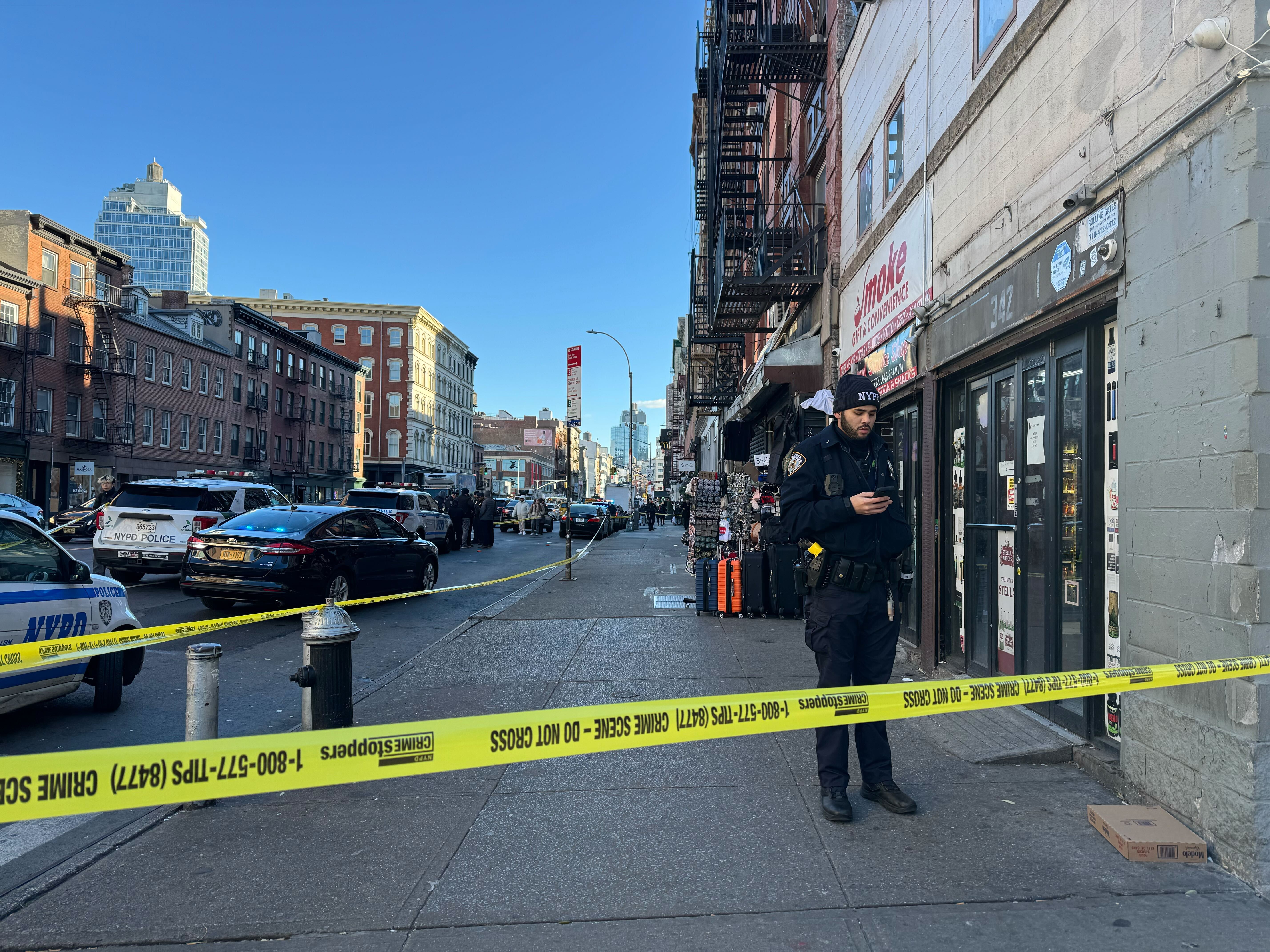 An NYPD officer stands outside a smoke shop on Canal Street in Manhattan on Dec. 6, 2024.