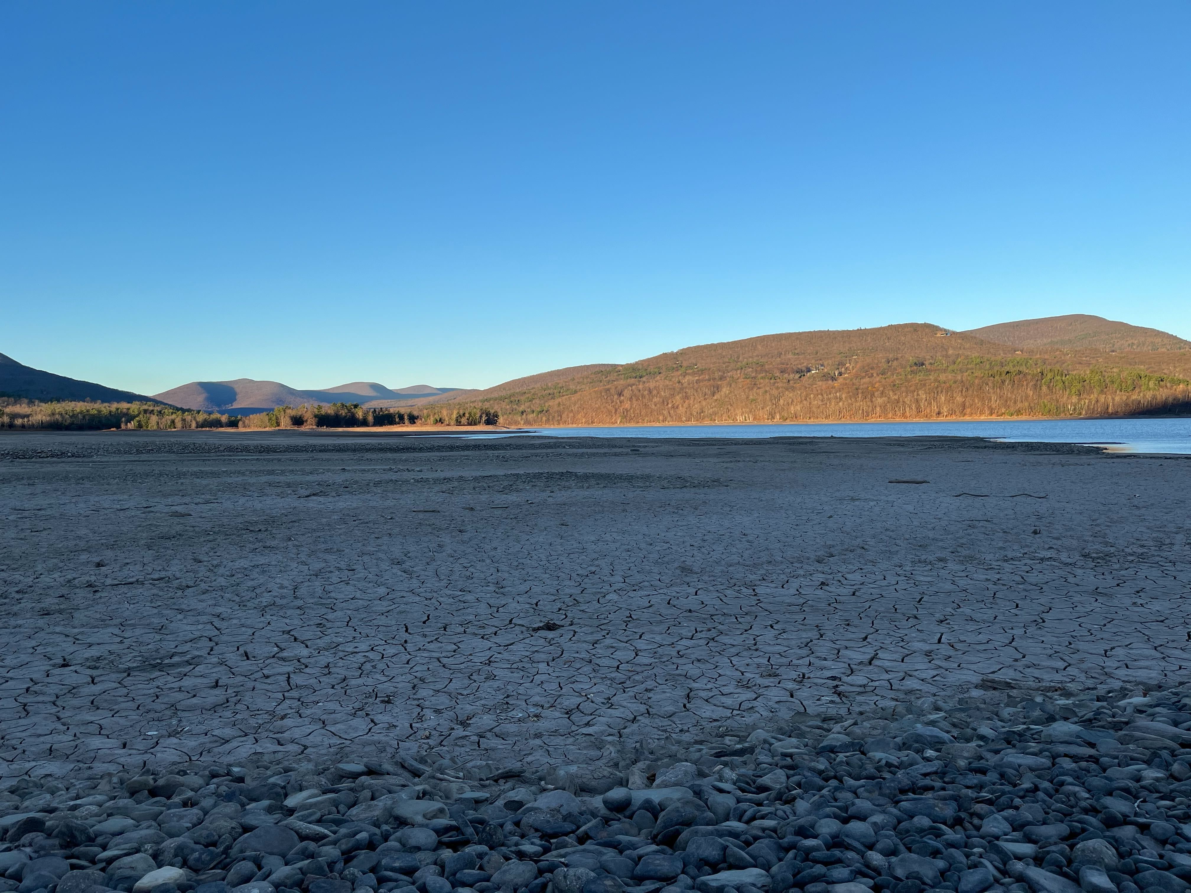 A dry reservoir with the ground cracked.