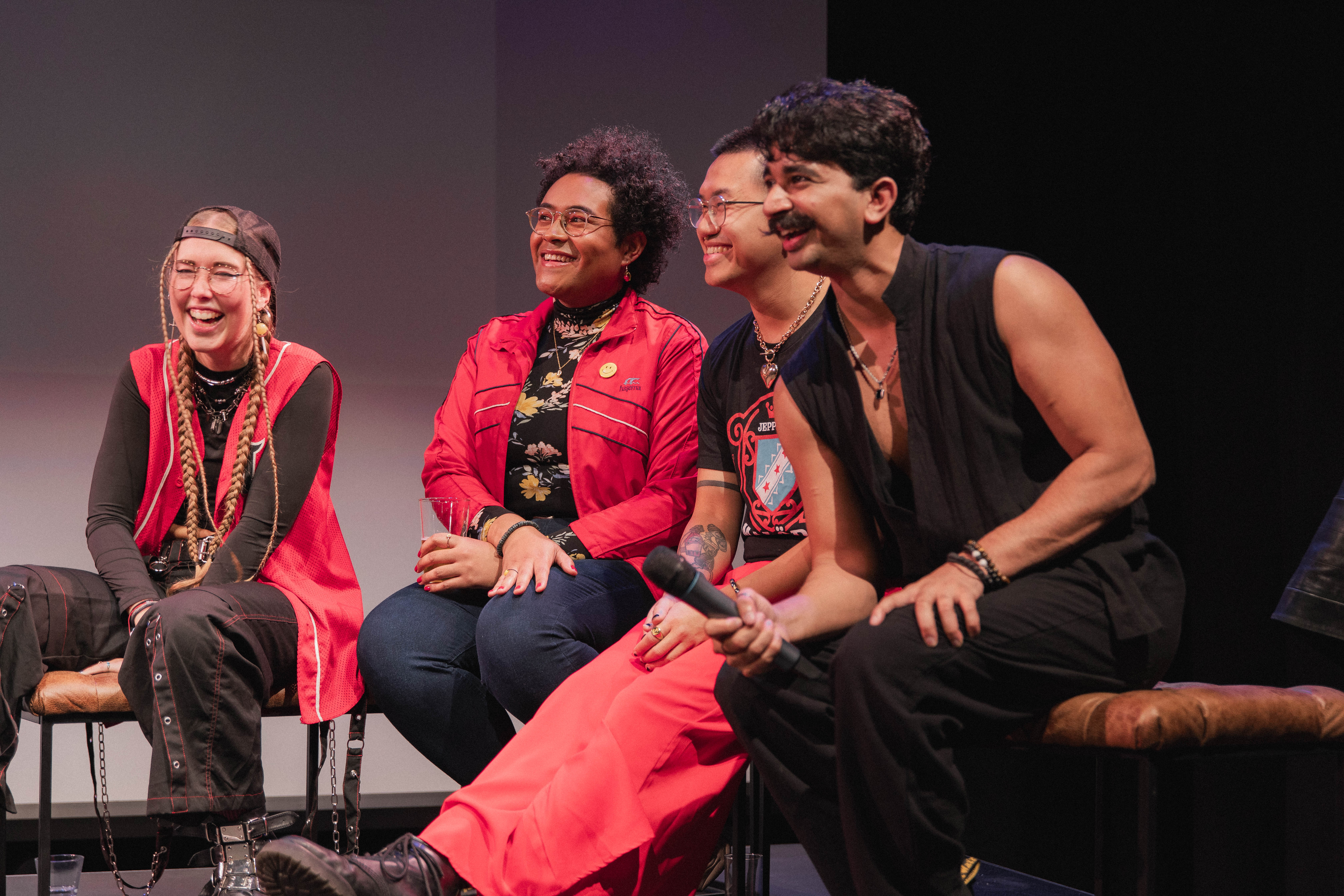 A group of people onstage on benches.