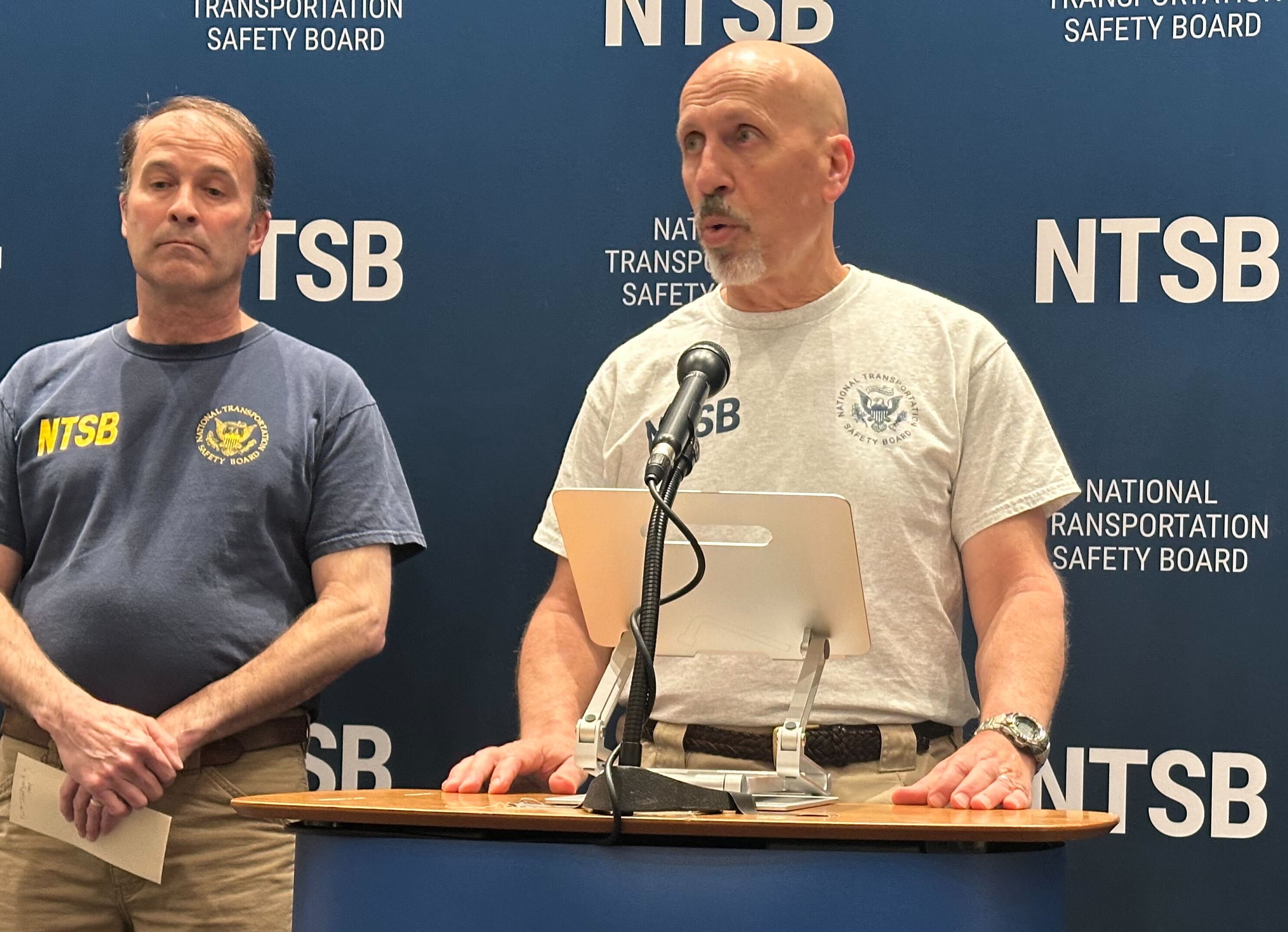 NTSB spokesperson Michael Graham speaks during a press briefing as investigator Brian Young stands by his side.