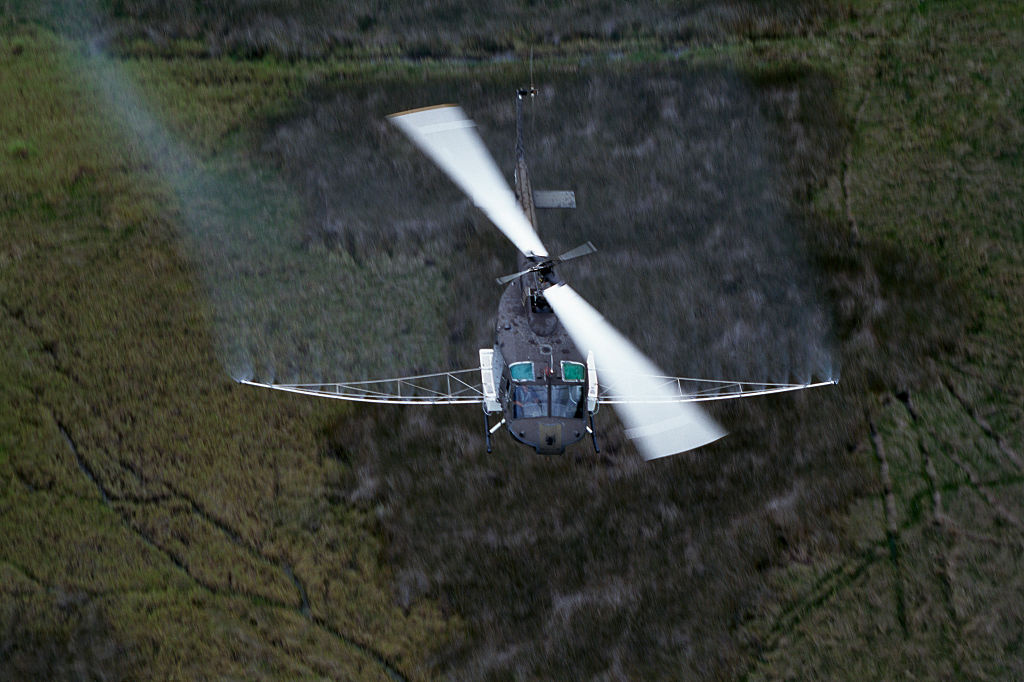 a helicopter spraying insecticide on mosquitoes