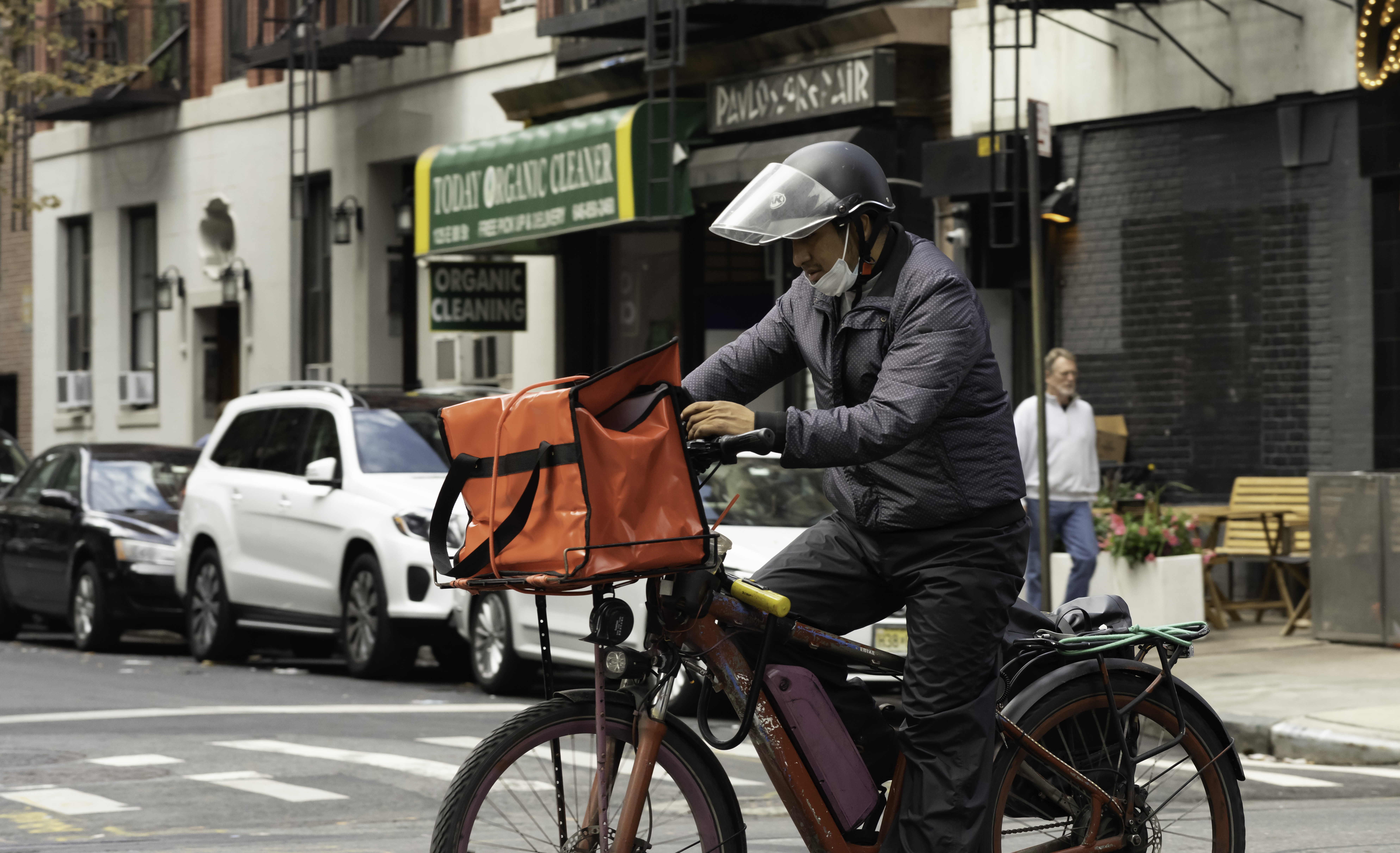 A stock photo of a delivery worker on an e-bike