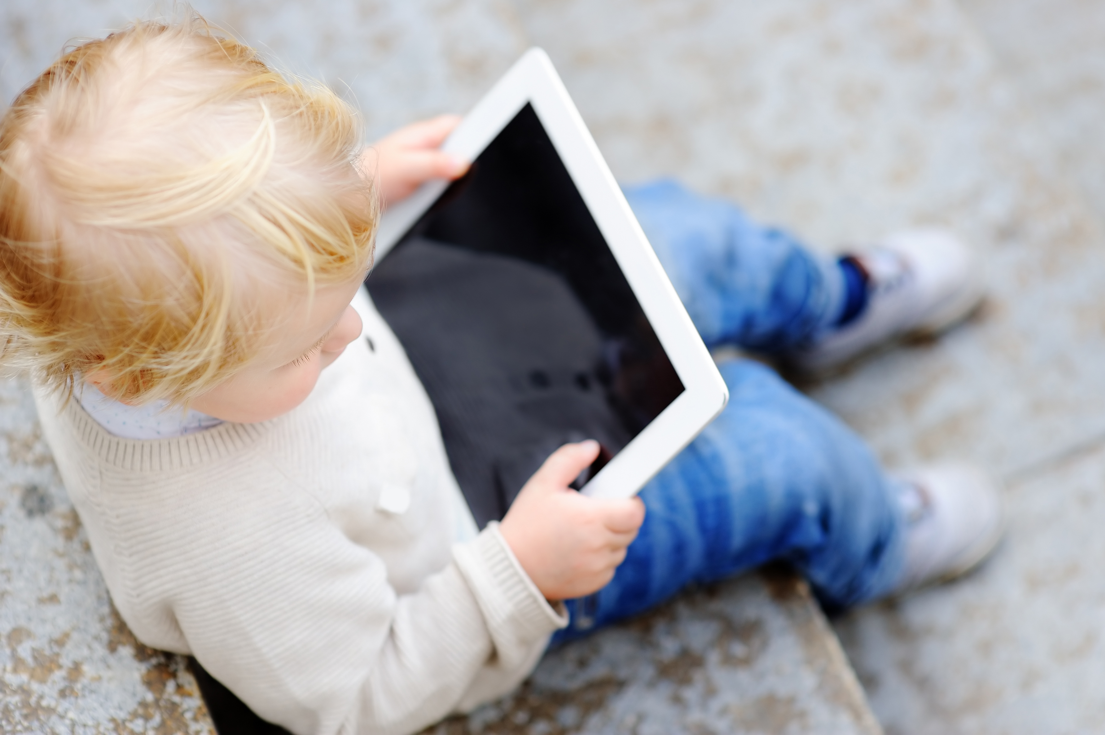 a kid holding an ipad