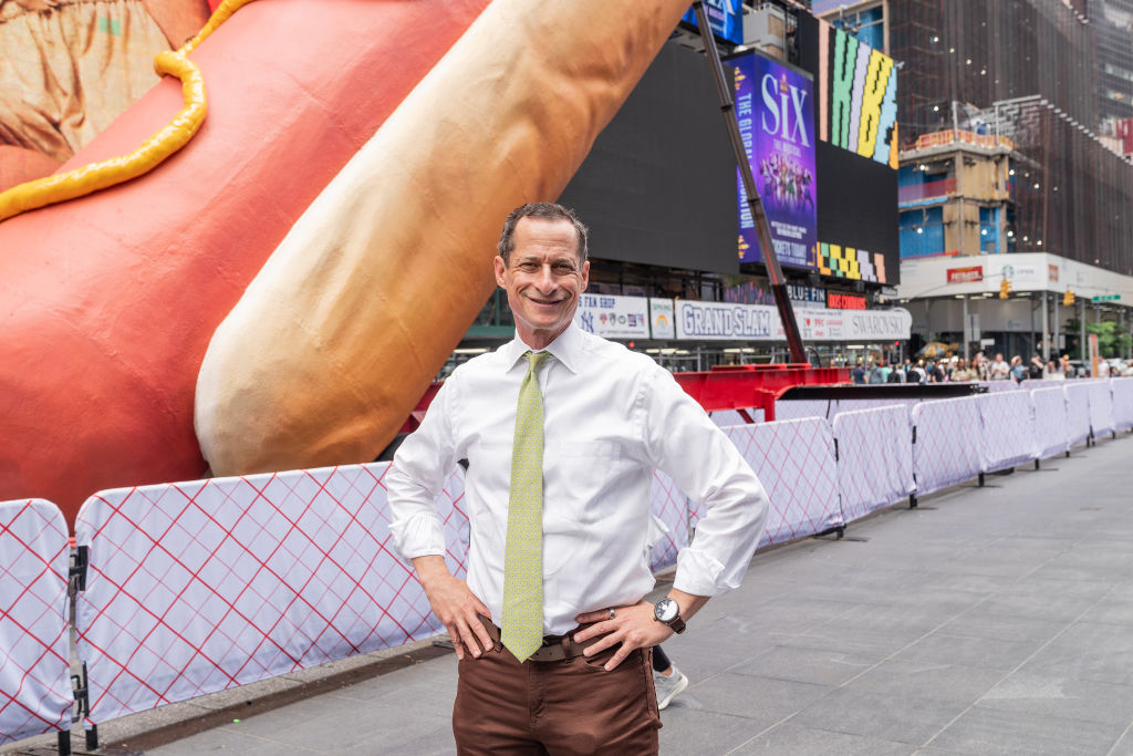 Anthony Weiner in front of a hot dog sculpture in Times Square