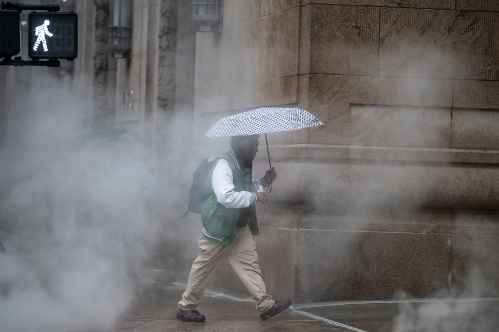 a guy with an umbrella walks through Manhattan